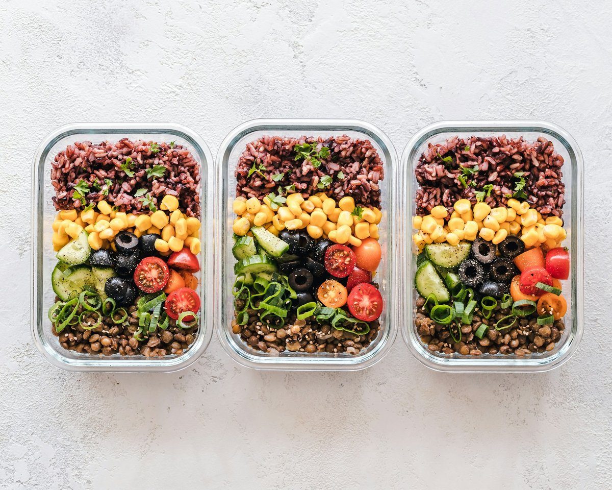 Trois boîtes en verre de riz, pois chiches et légumes crus