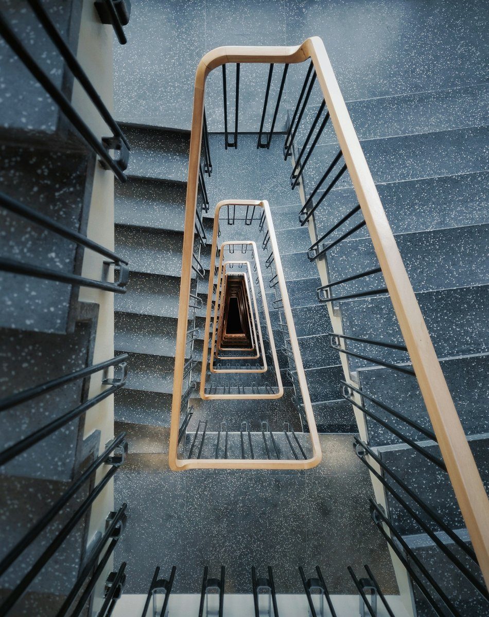 Cage d'escalier vue d'en haut avec une rampe en bois