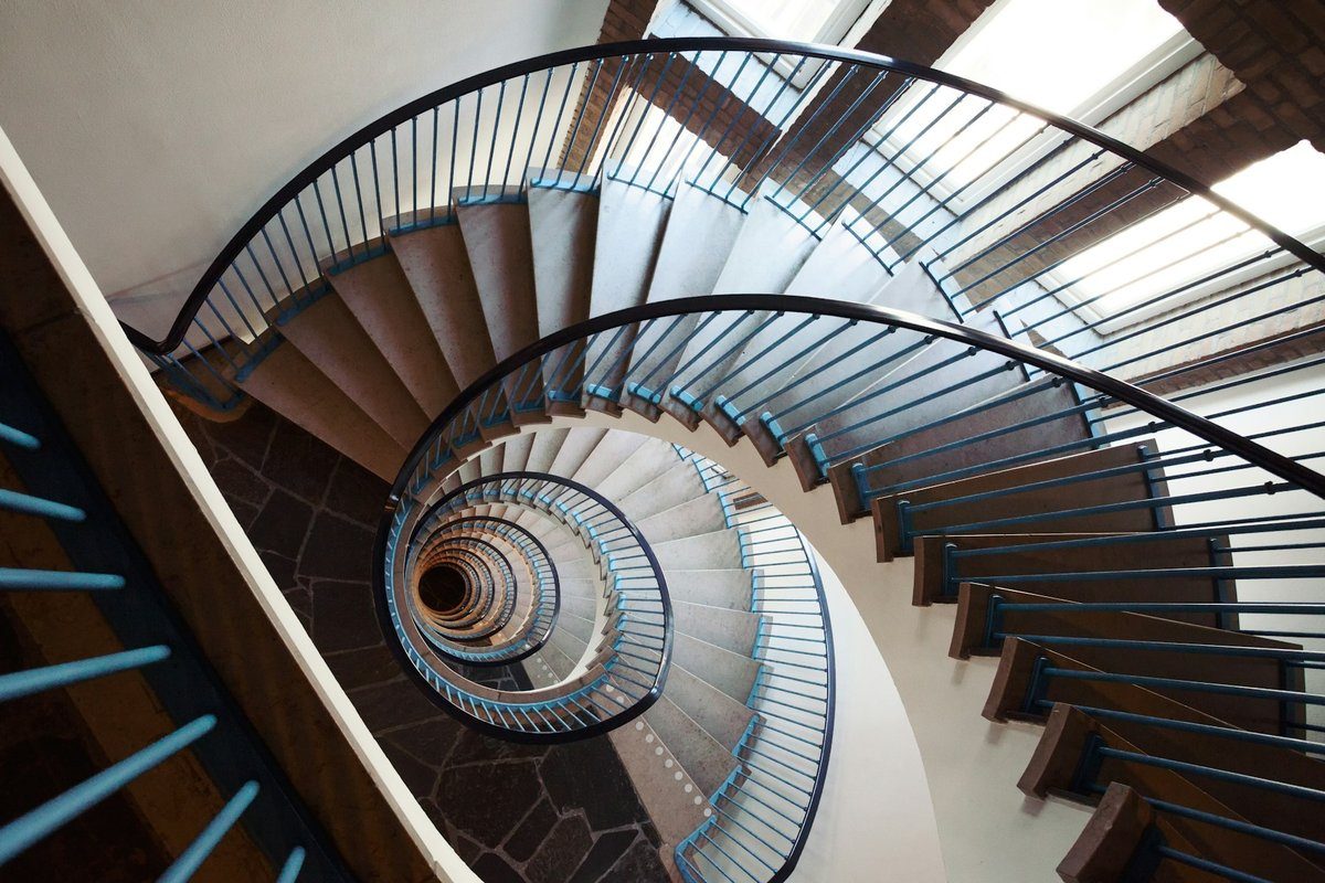 Escalier en colimaçon vu d'en haut, les marches s'enroulant vers le bas