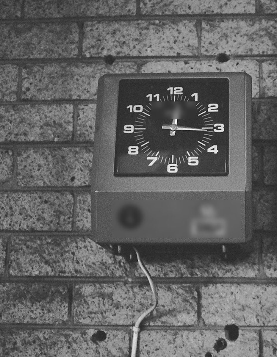 Ancienne horloge de pointage murale fixée sur un mur de briques, photo en noir et blanc